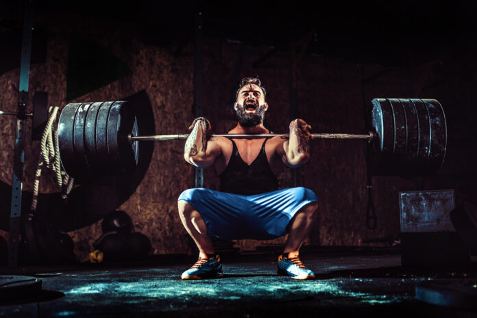 Young man getting started with weightlifting to build strength