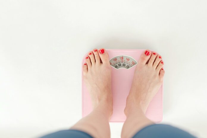 Young woman measuring weight loss